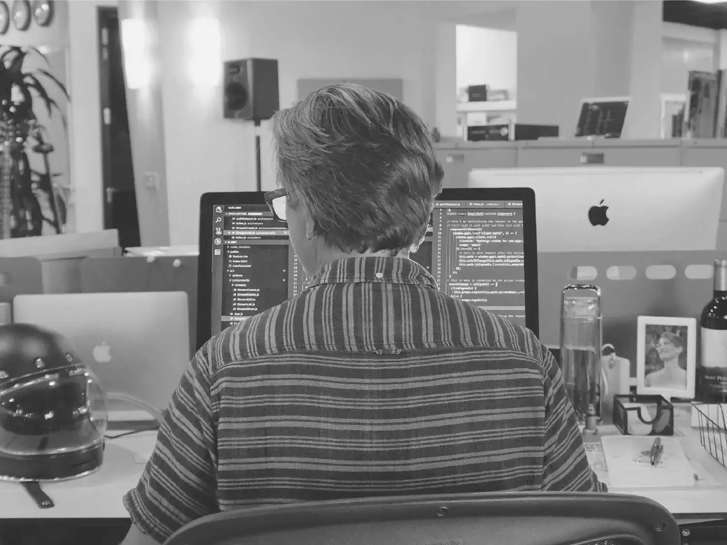A developer at a desk with two monitors showing code